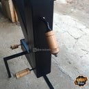 Churrasqueira preta com alças de madeira em chão de concreto para churrasco e grelha