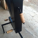 Detalhe de alavancas com pegadas de madeira em equipamento preto sobre piso de concreto