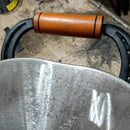 Alça de madeira e metal de ferramenta agrícola com superfícies desgastadas em fundo de chão de oficina